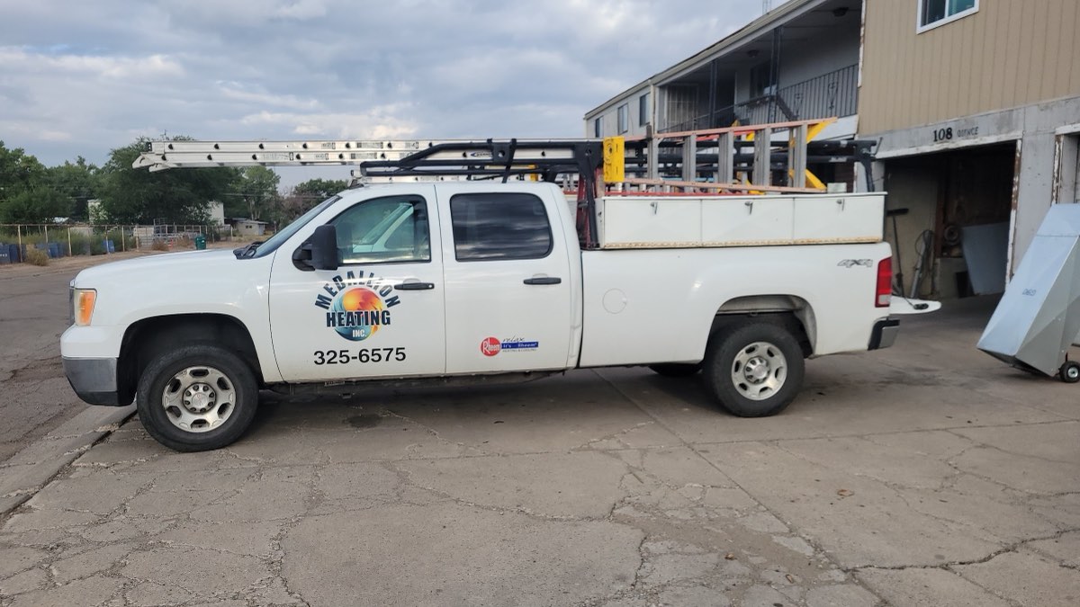 Medallion Heating branded service truck with phone number, parked at the shop on West Quince Street in Farmington